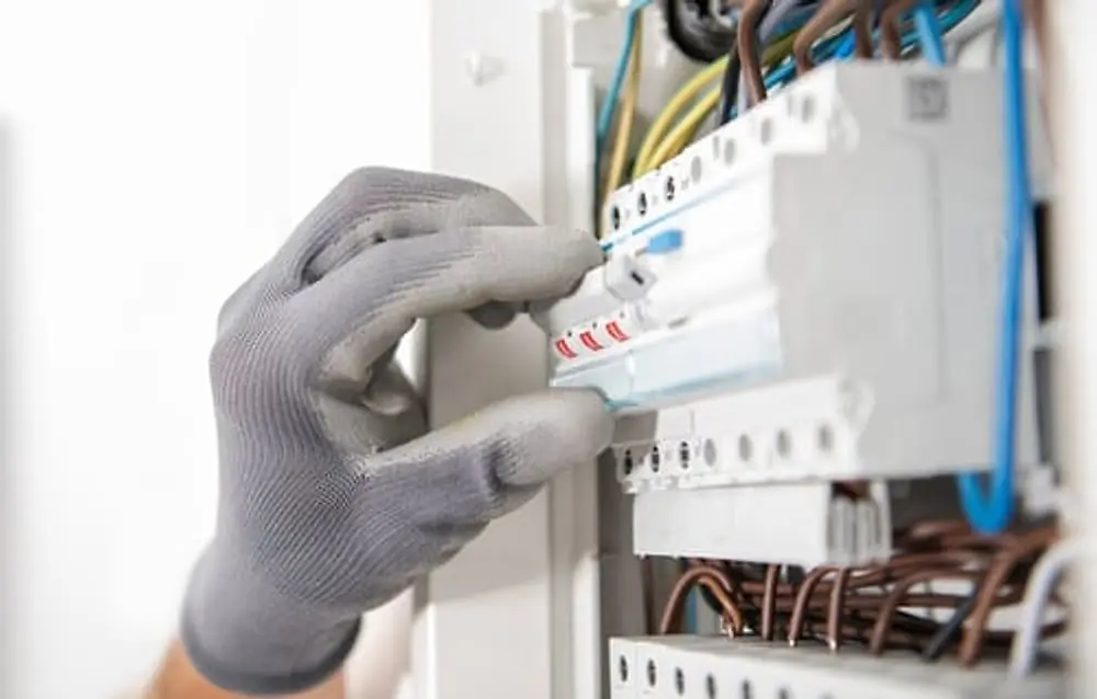 Just Electric LLC electrician testing connections inside a service panel